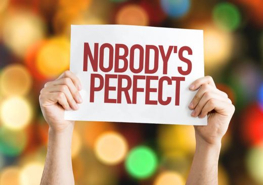 hands holding up sign that says nobody's perfect