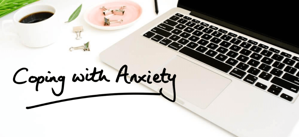 image of white table with open laptop cup of coffee and plants with caption that says coping with anxiety