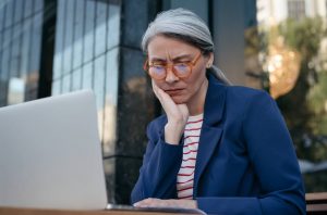 femme person staring at laptop looking concerned and confused about what to do next