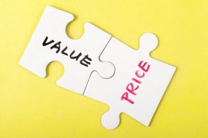 white puzzle pieces on yellow background both connected one says value one says price