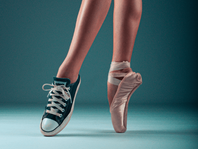 image of dancer wearing sneaker on one foot and pointe shoe on another to indicate different personas