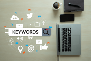 concept for SEO keywords with social media symbol graphics and laptop, phone, coffee, and notebook